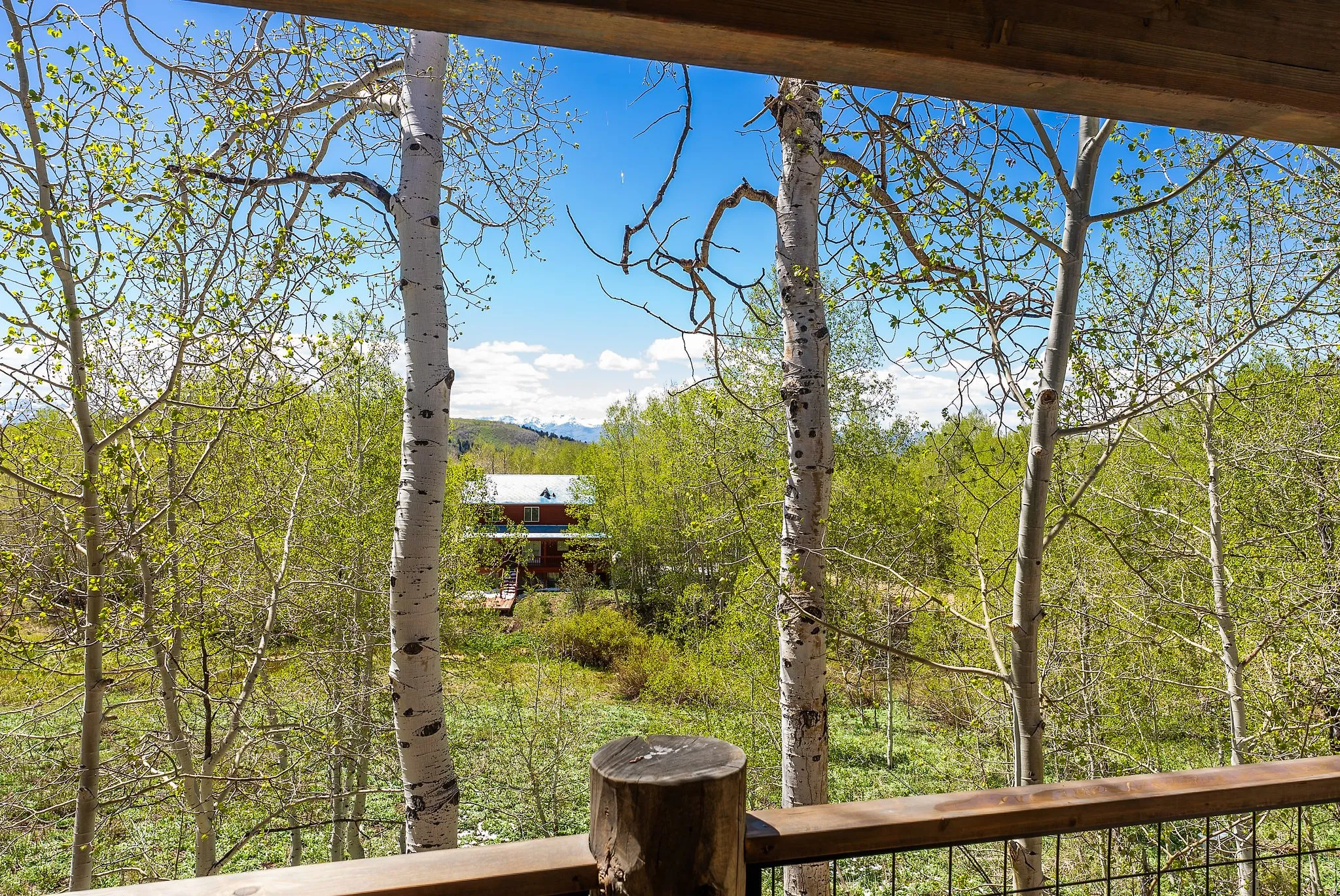 Balcony with a wood top rail, metal railing, and a wood support post
