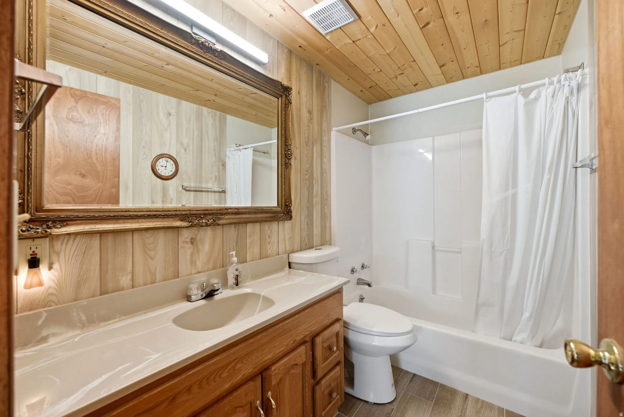 Bathroom featuring plank wood ceiling, wood-finish wall panels, and wood-finish flooring