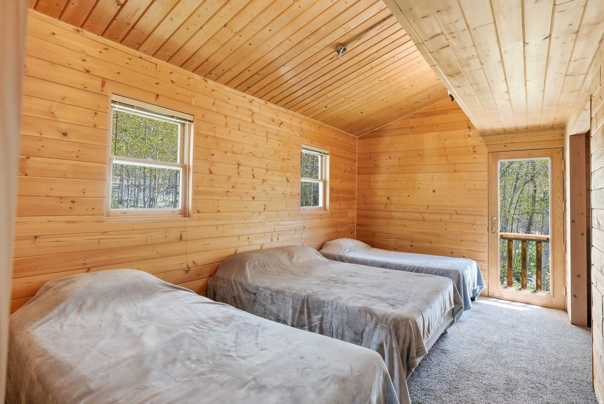 Interior room with natural wood-paneled walls and a vaulted wood-paneled ceiling