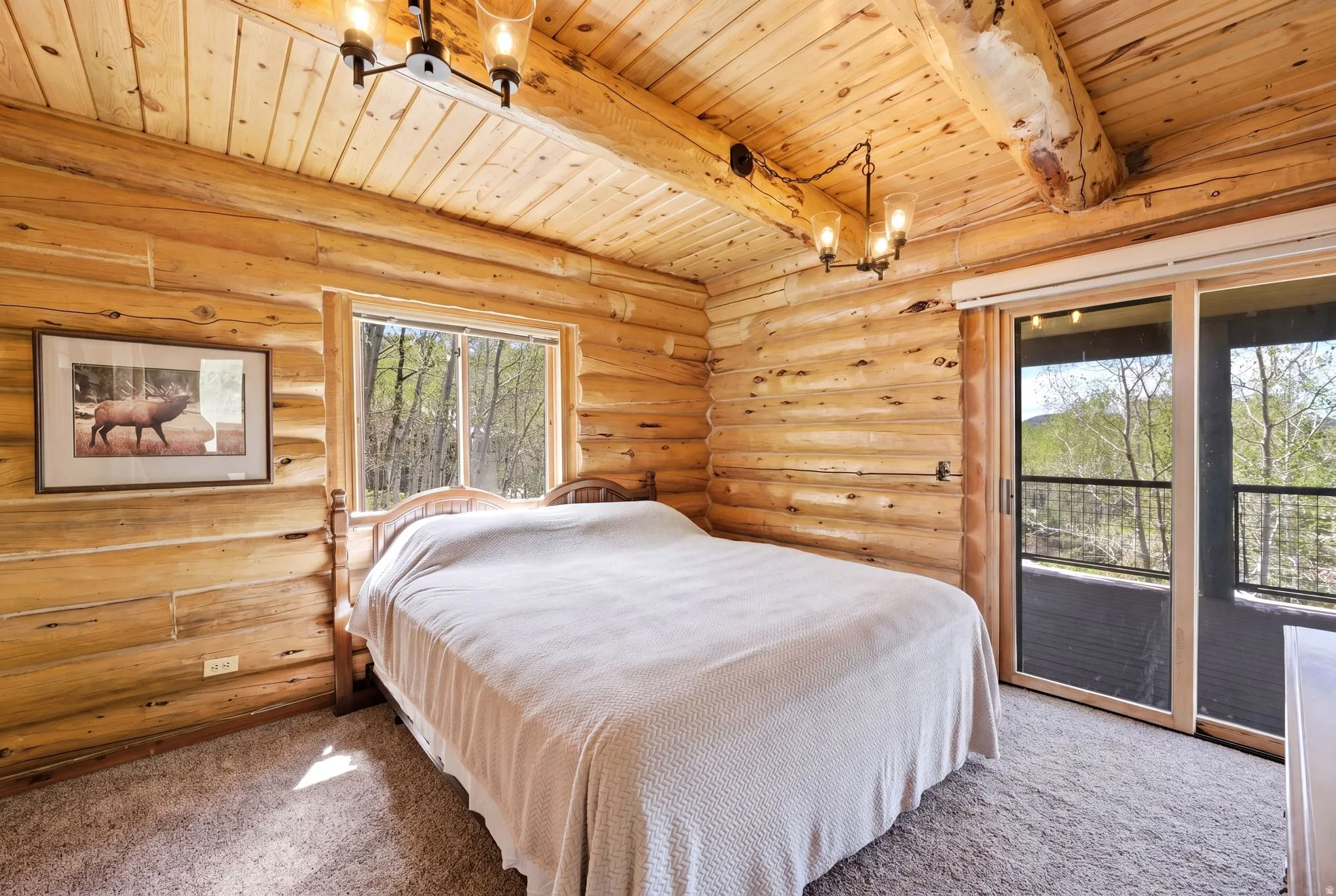 Log construction room featuring a window and sliding glass door