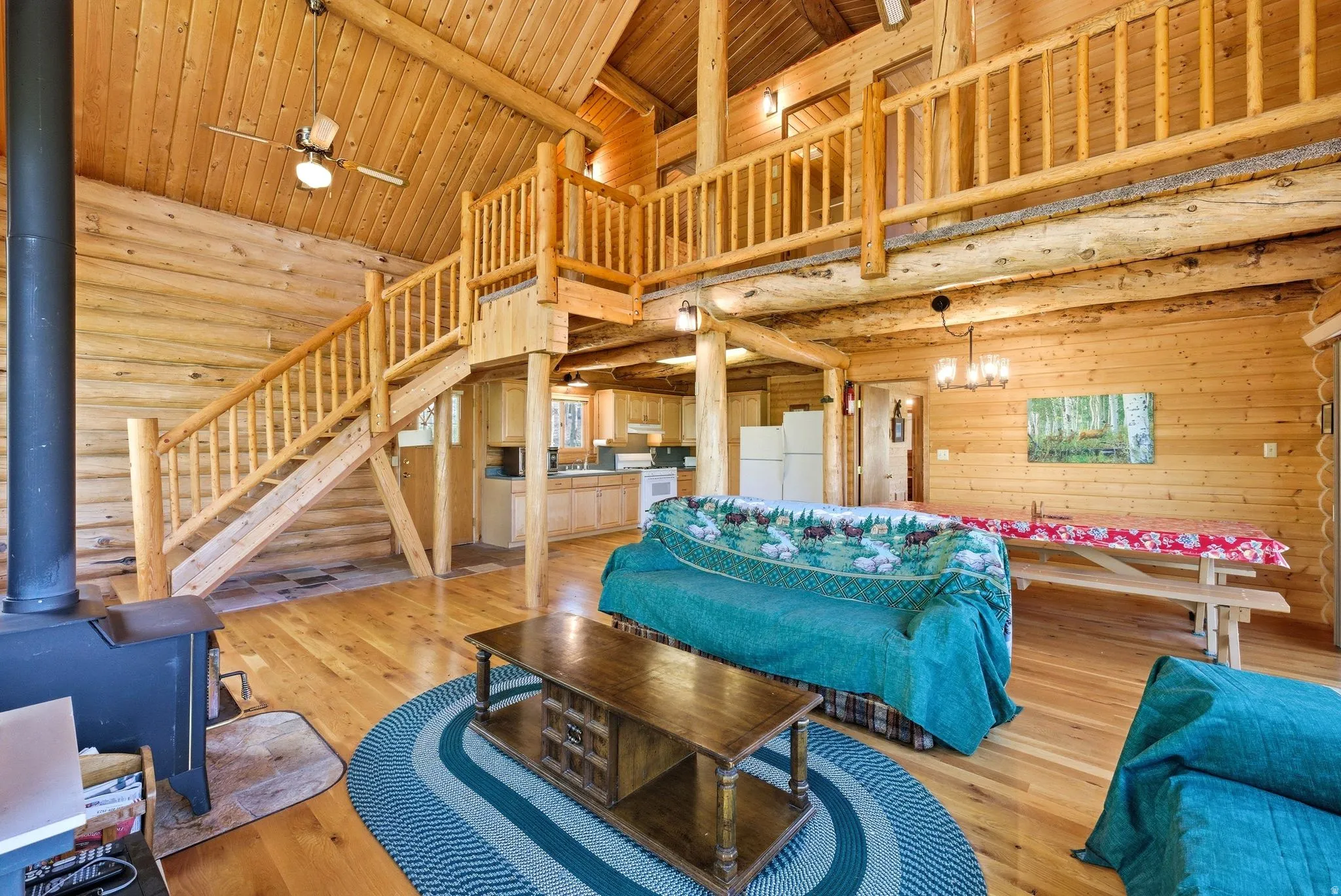 Vaulted wood-finish ceilings, an exposed timber staircase, and wood-finish flooring characterize this interior space