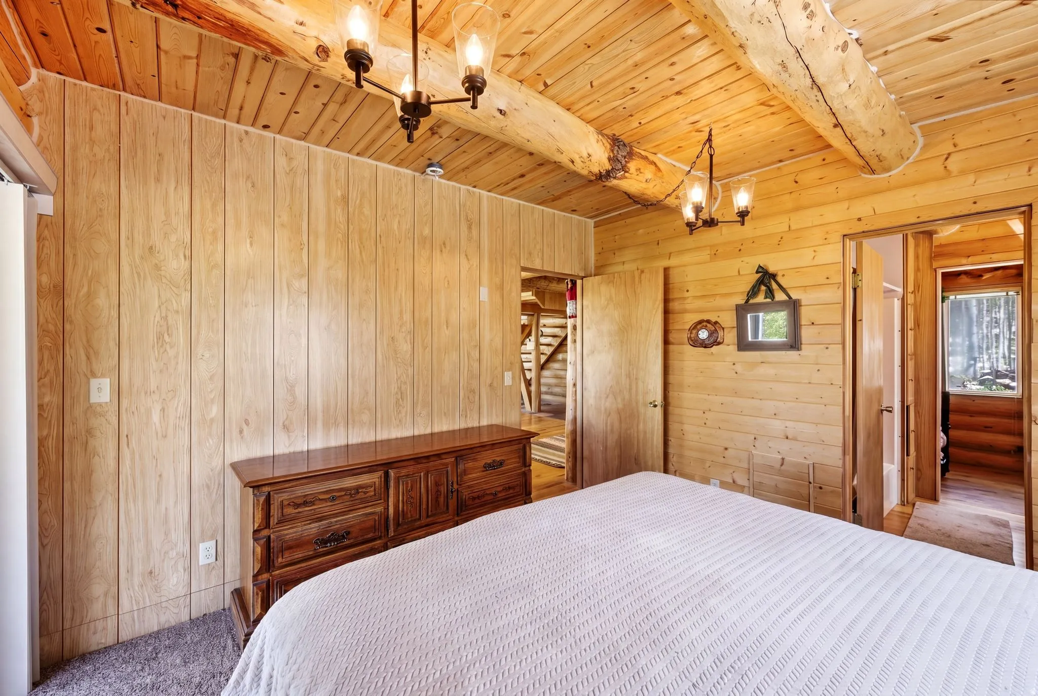 Interior room featuring wood-paneled walls and a wood-planked ceiling with exposed log beams