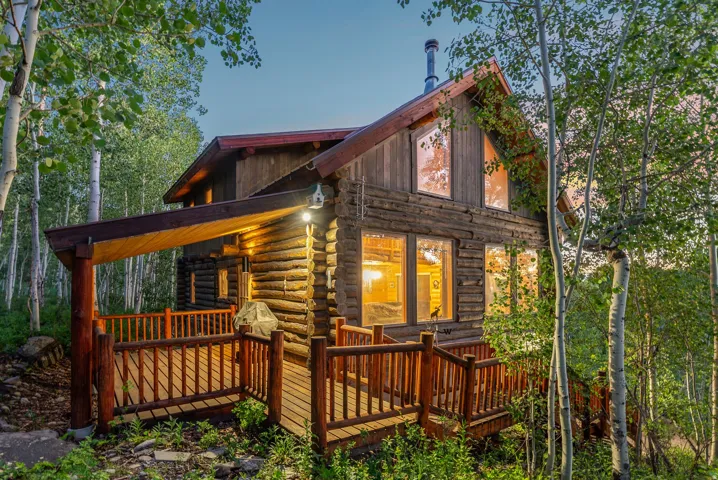 Log cabin exterior with an expansive wooden deck and a covered porch