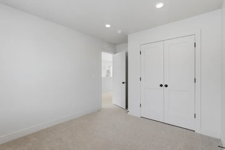 Bedroom featuring neutral carpeting and white baseboards