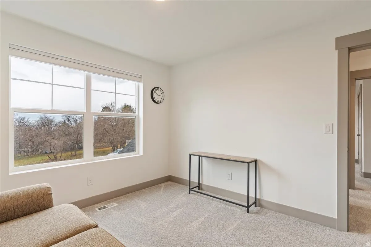 Bright room featuring a large four-pane window with a verdant outdoor landscape