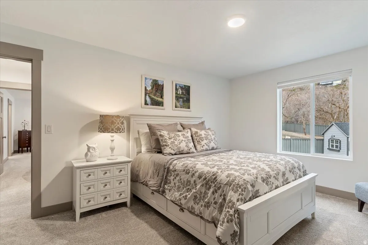 Spacious room featuring neutral carpeting, a large window, recessed lighting, and a doorway with contrasting trim