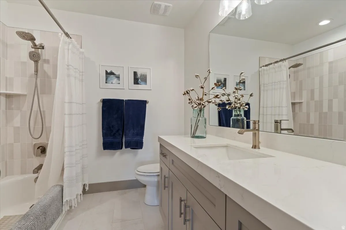 Bathroom featuring a light gray vanity with brushed nickel hardware, a white countertop, and an integrated rectangular sink