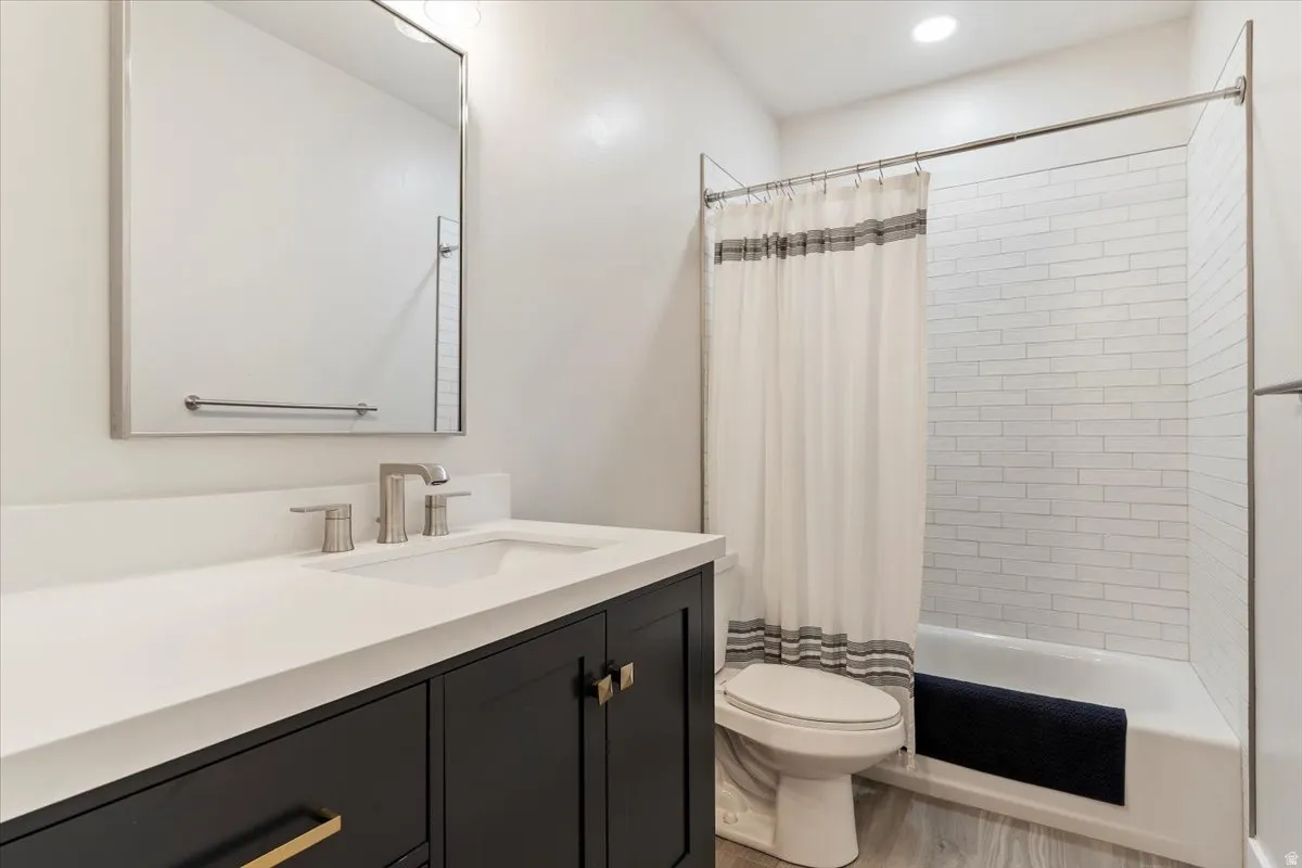 Bathroom featuring a dark vanity with a white countertop, under-mount sink, and brushed nickel fixtures