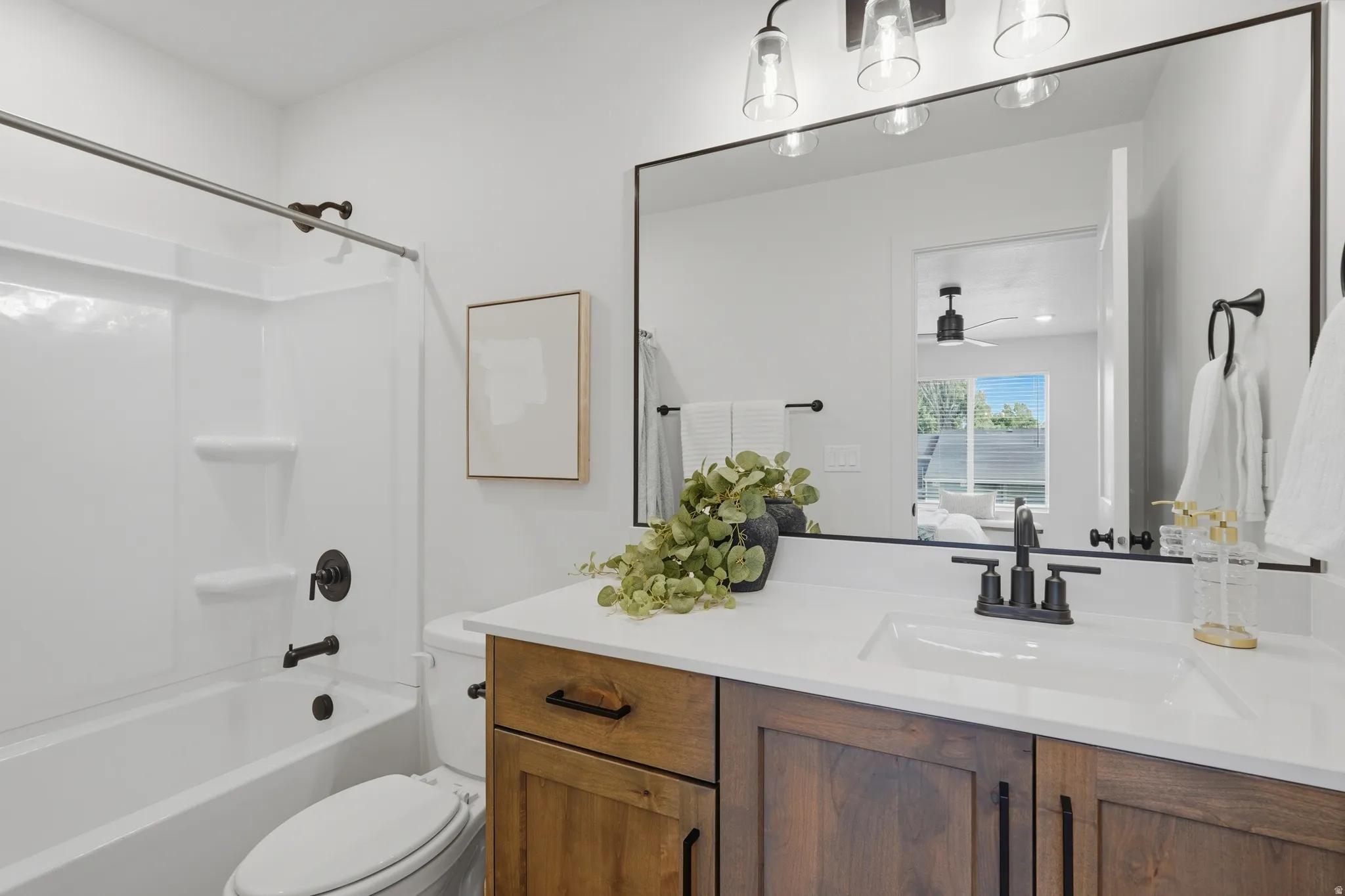 Bathroom featuring a wood-finish vanity with an integrated sink and white countertop