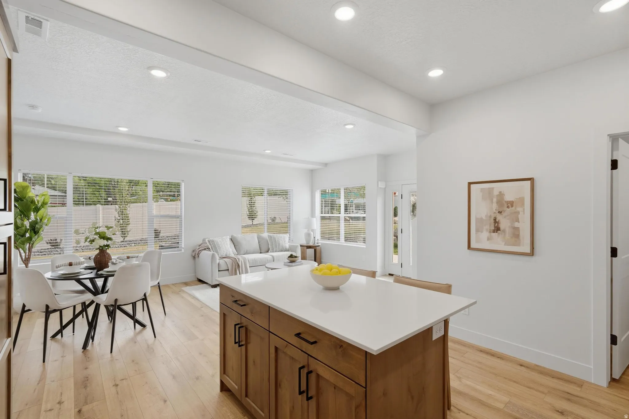 Central kitchen island with wood-finish cabinetry and a light-toned countertop