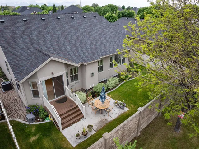 Rear exterior featuring a multi-level deck, concrete patio, and manicured lawn