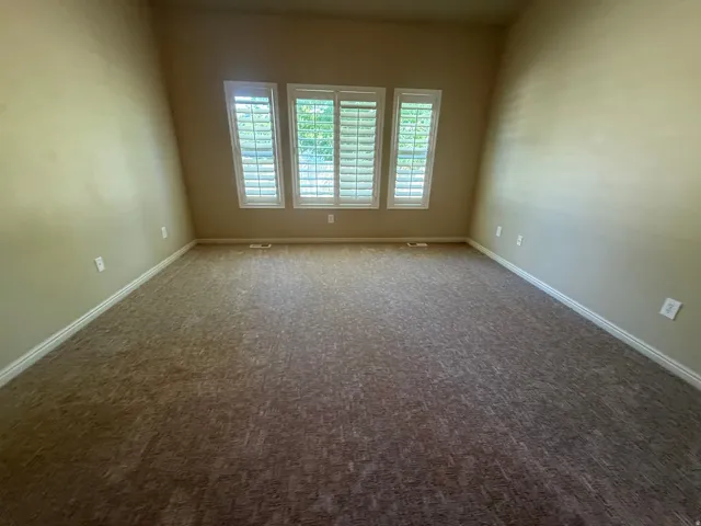 Neutral-toned walls complement patterned carpeting