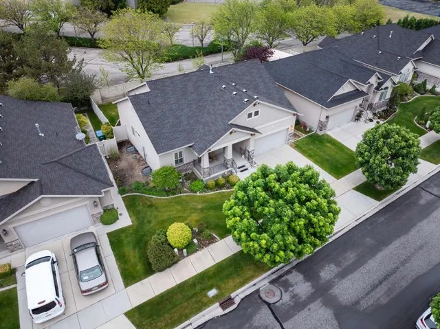 Traditional-style residence featuring a dark shingle roof, light-toned siding, and a stone facade accent