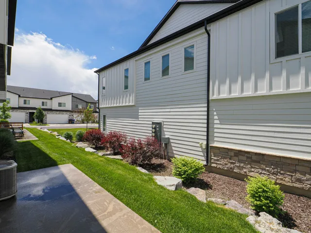 Contemporary exterior featuring horizontal siding, vertical board and batten accents, and a stone veneer foundation