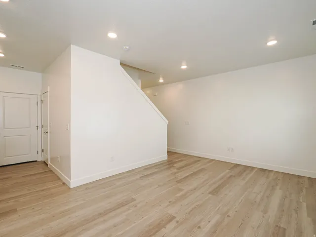 Spacious interior featuring light wood-finish flooring, recessed lighting, white walls, and bright white trim