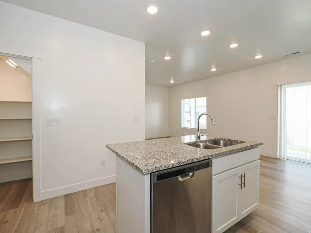 Kitchen island with a double basin sink, gooseneck faucet, and integrated stainless steel dishwasher