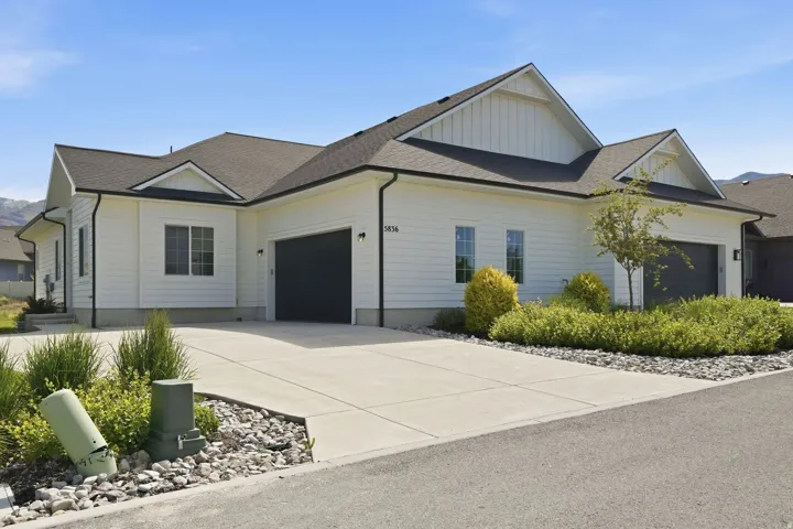 Single-story residence featuring white horizontal siding and dark-trimmed windows