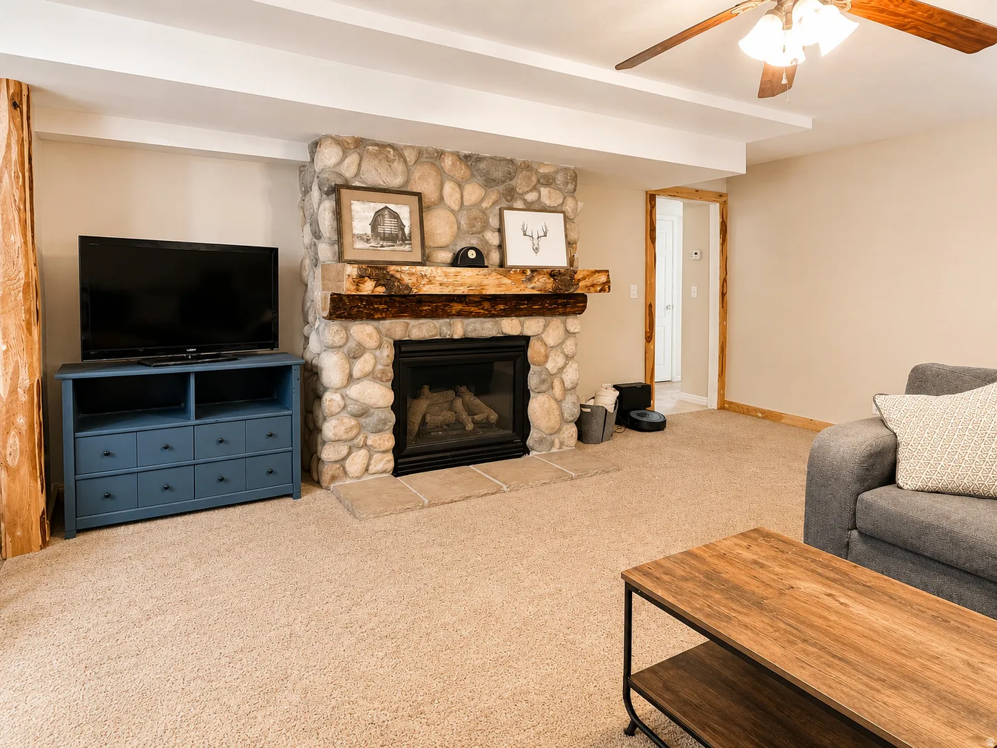 Basement Living area with a stone-faced gas fireplace.