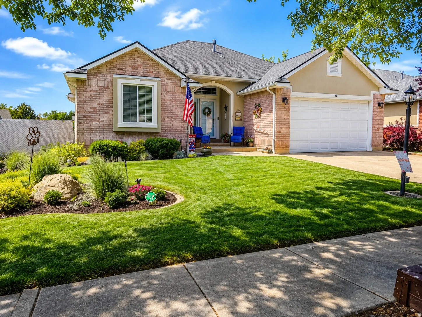 Brick and stucco facade home with arched entry and a prominent two-car garage
