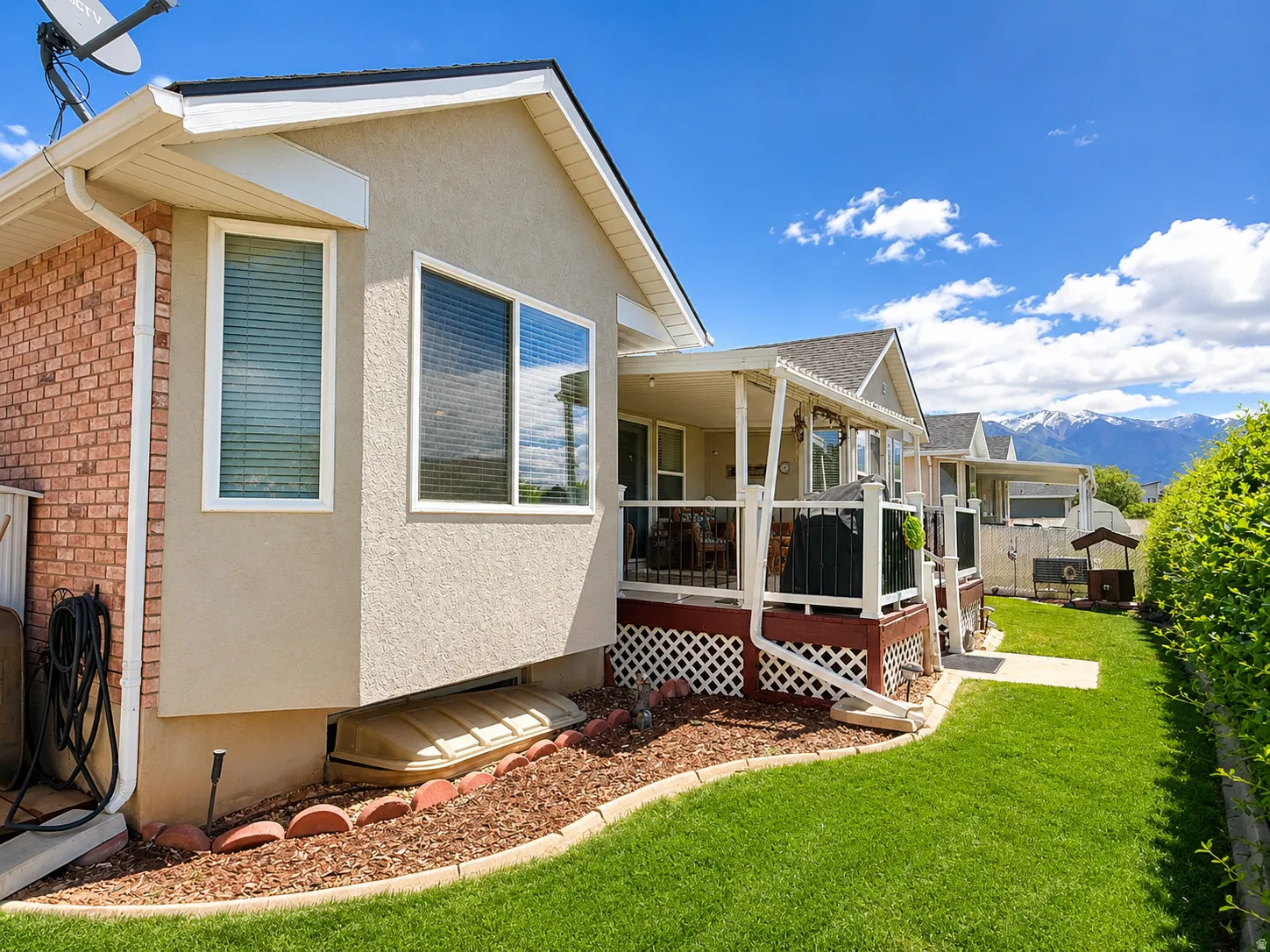 Exterior featuring a covered patio, stucco siding, and brick accents