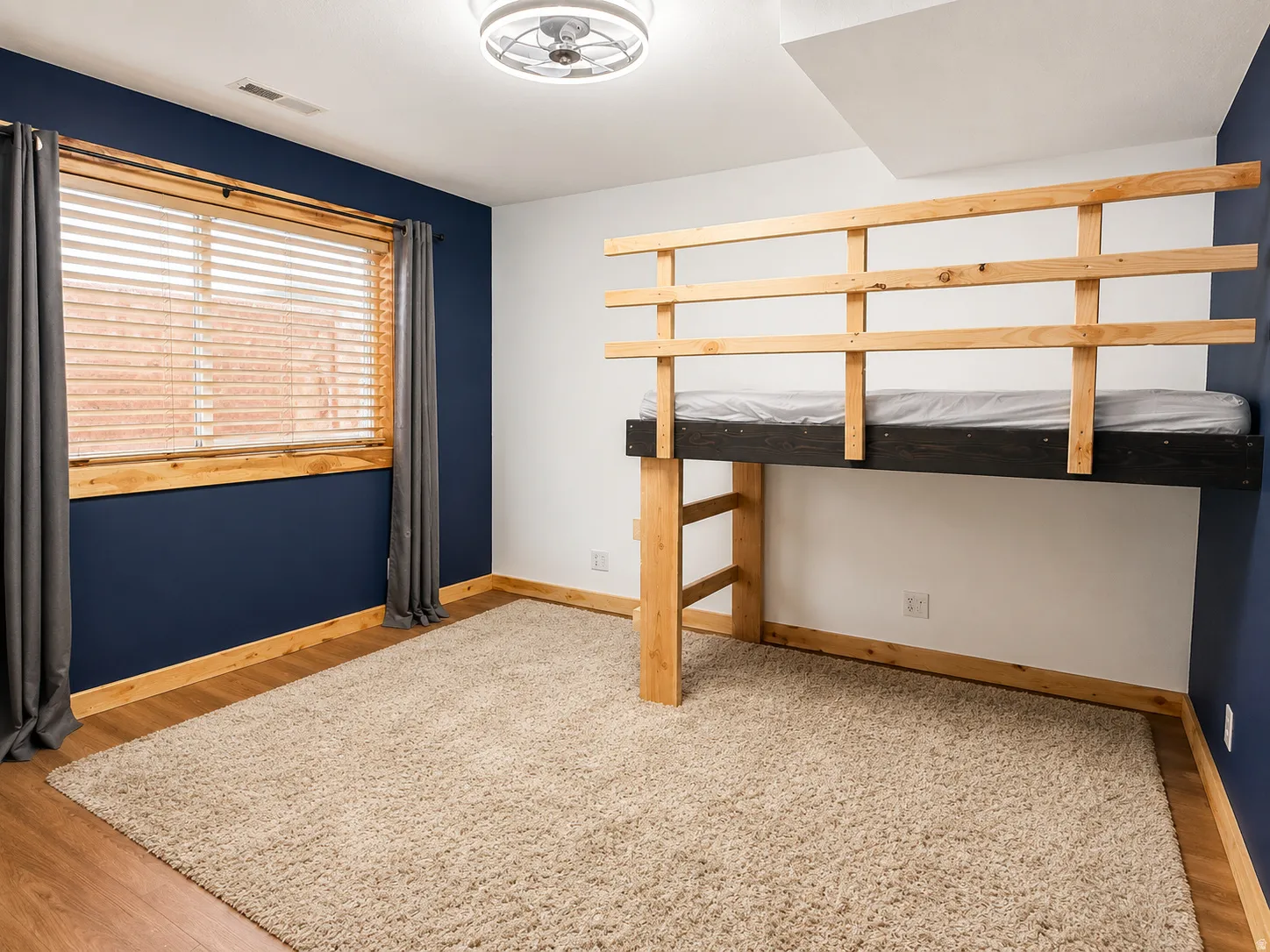 Basement Bedroom featuring a built-in loft bed frame with a natural wood finish