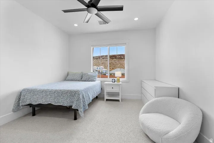 Bright bedroom featuring a ceiling fan with integrated lighting, recessed lighting, and white walls