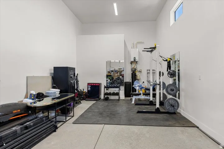 Interior space featuring high ceilings, a rectangular transom window, concrete flooring, and a large black mat area