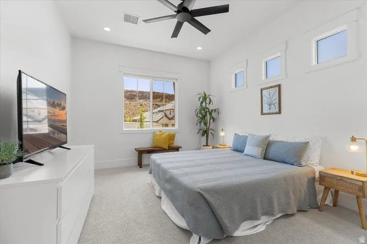 Carpeted bedroom with a black ceiling fan