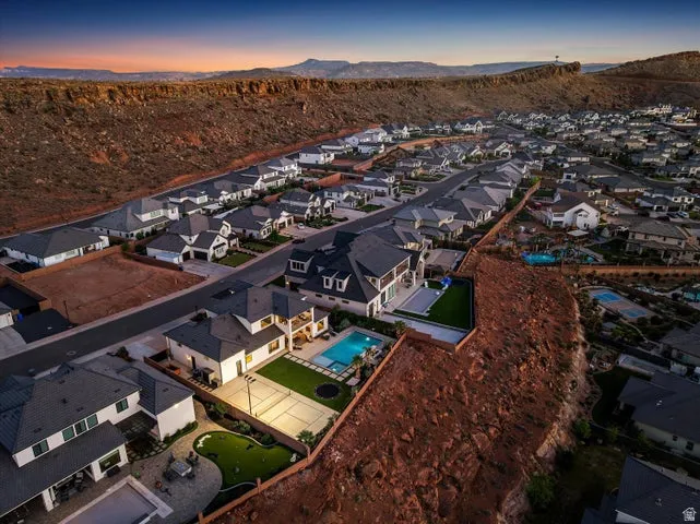 Aerial perspective showcasing a residential community nestled against a rugged, mountainous backdrop