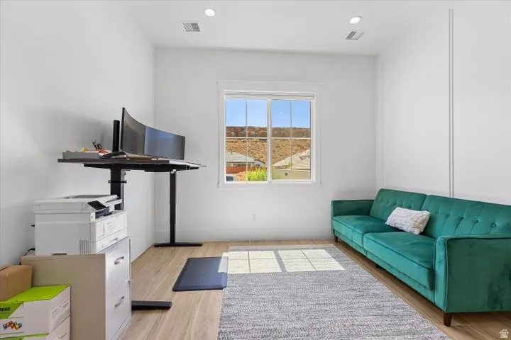 Bright room with a large window, recessed lighting, and wood-finish flooring