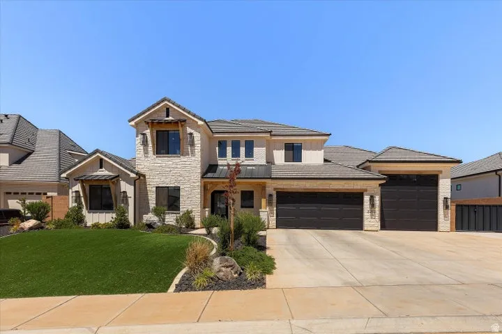 Contemporary exterior featuring stone and stucco finishes, multiple gables, and a concrete driveway