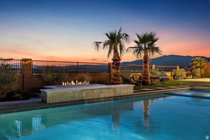Resort-style pool with integrated fire feature and water spillway