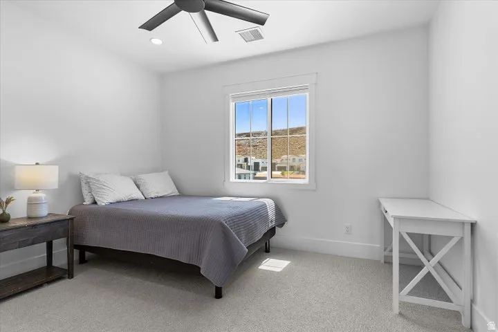 Bright room featuring a window with grid patterns, a ceiling fan, and recessed lighting