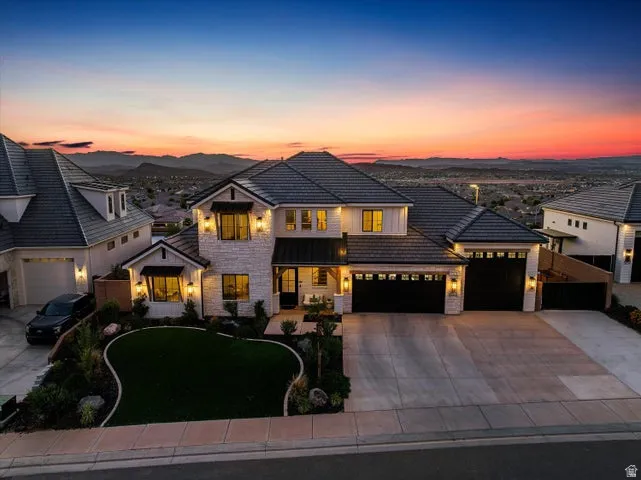Modern Farmhouse style residence featuring a stone and siding exterior, multiple gabled roofs, and a concrete driveway