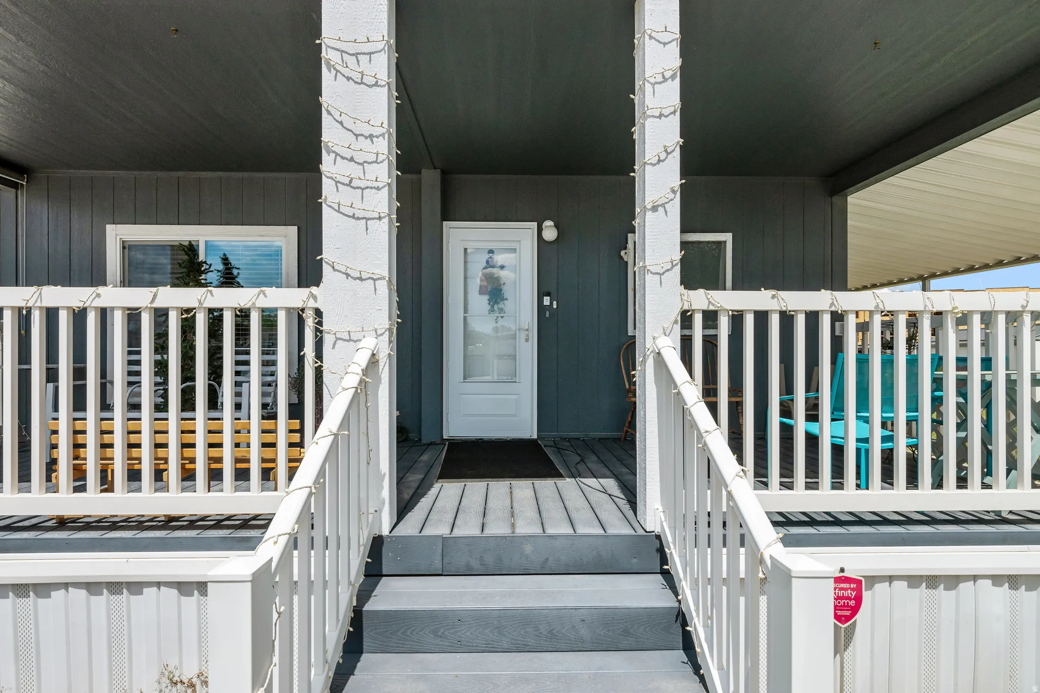 Covered front porch with white railings and gray steps