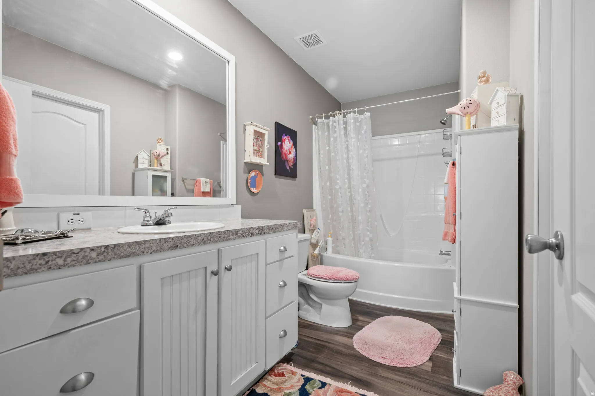 Bathroom featuring a white vanity with beadboard cabinet doors, a drop-in sink, and a speckled countertop