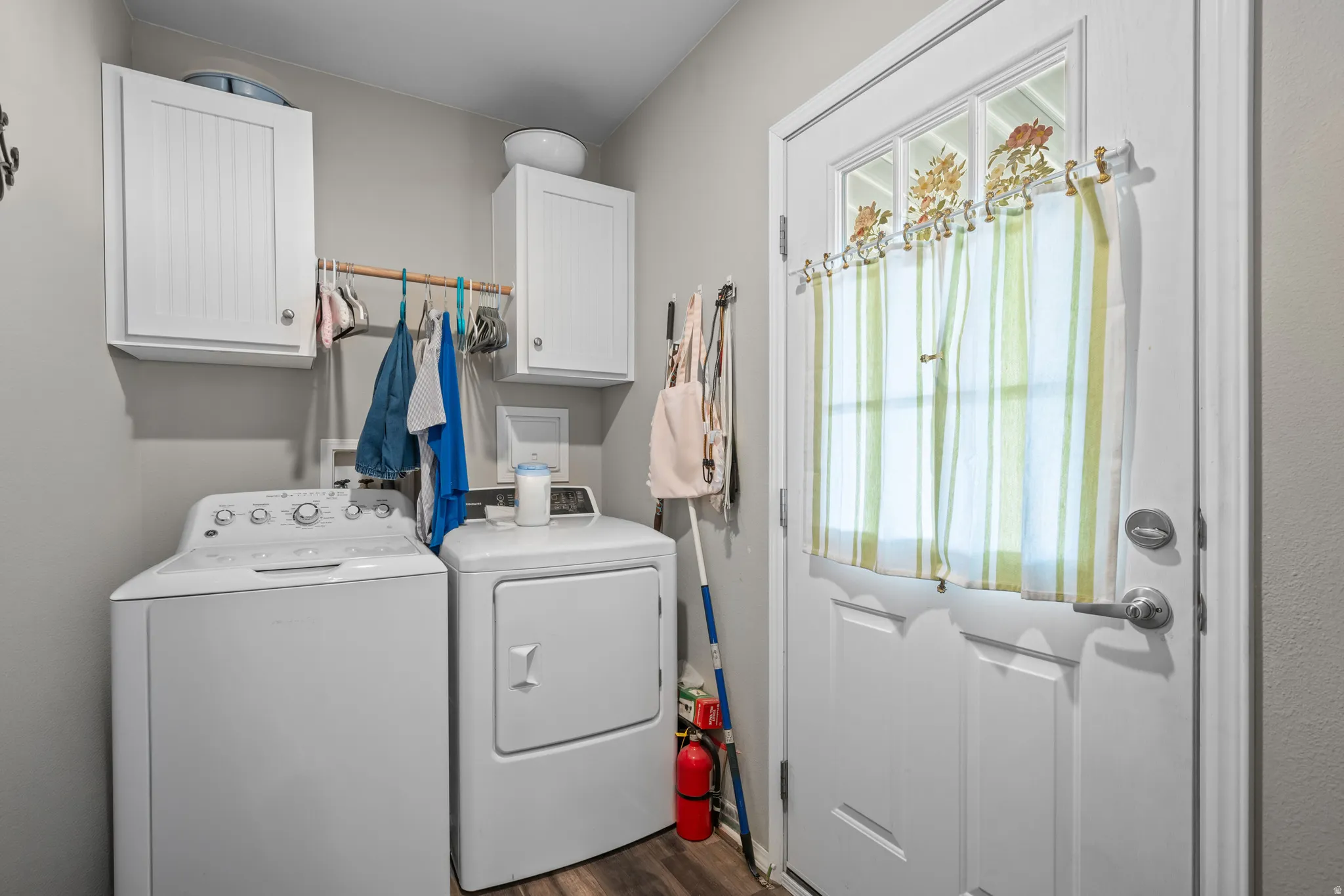 Dedicated laundry area featuring wood-finish flooring and light gray walls