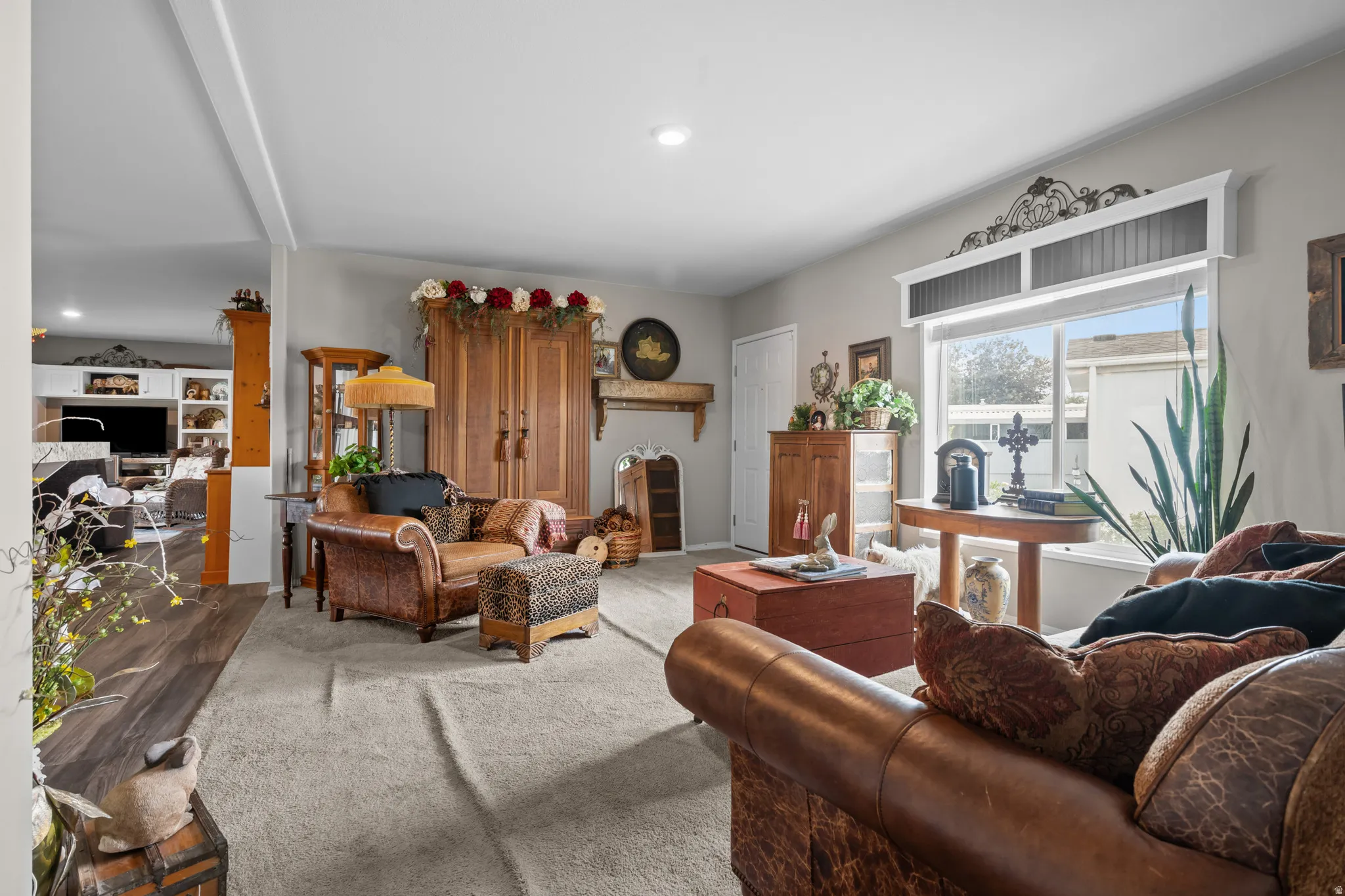 Spacious living area featuring light gray wall paint, recessed lighting, and a large window with a decorative valance