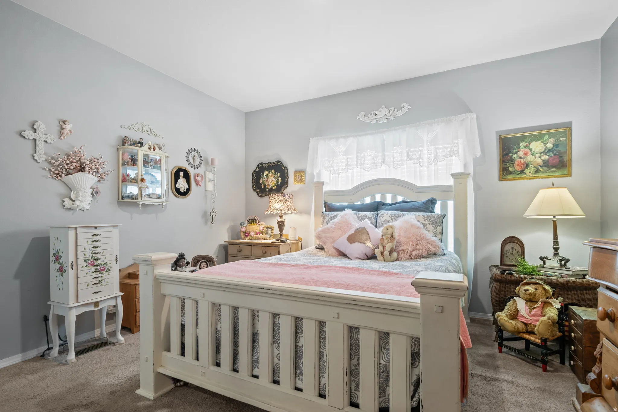 Carpeted flooring throughout, light gray wall paint, and a built-in window with white lace curtains