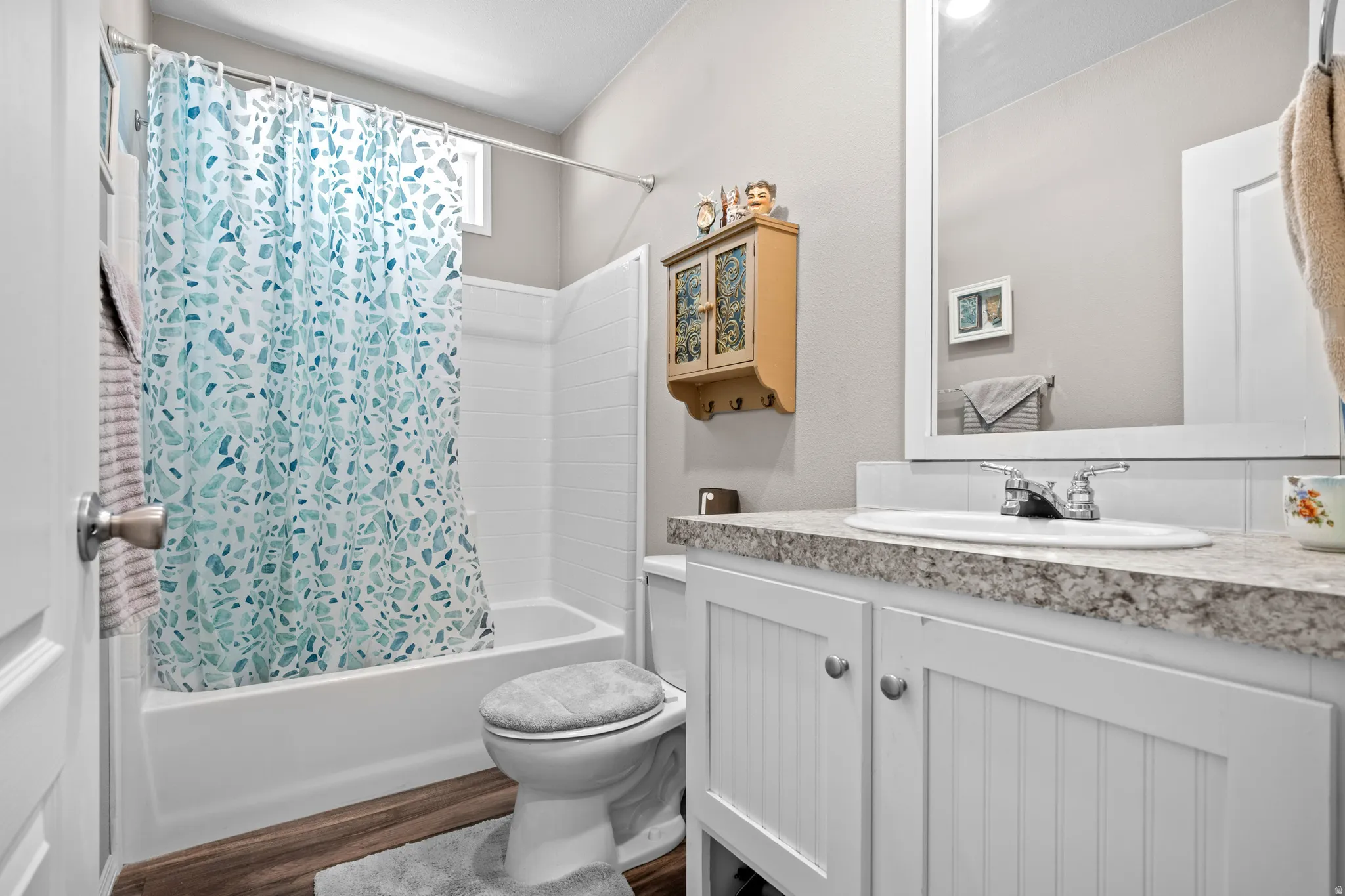 Bathroom featuring a white vanity with beadboard paneling, stone-finish countertop, and undermount sink