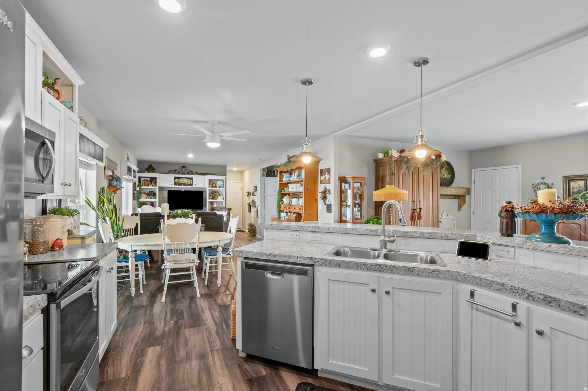 Kitchen featuring a double basin sink with a gooseneck faucet, white beadboard cabinetry, and light-toned speckled countertops