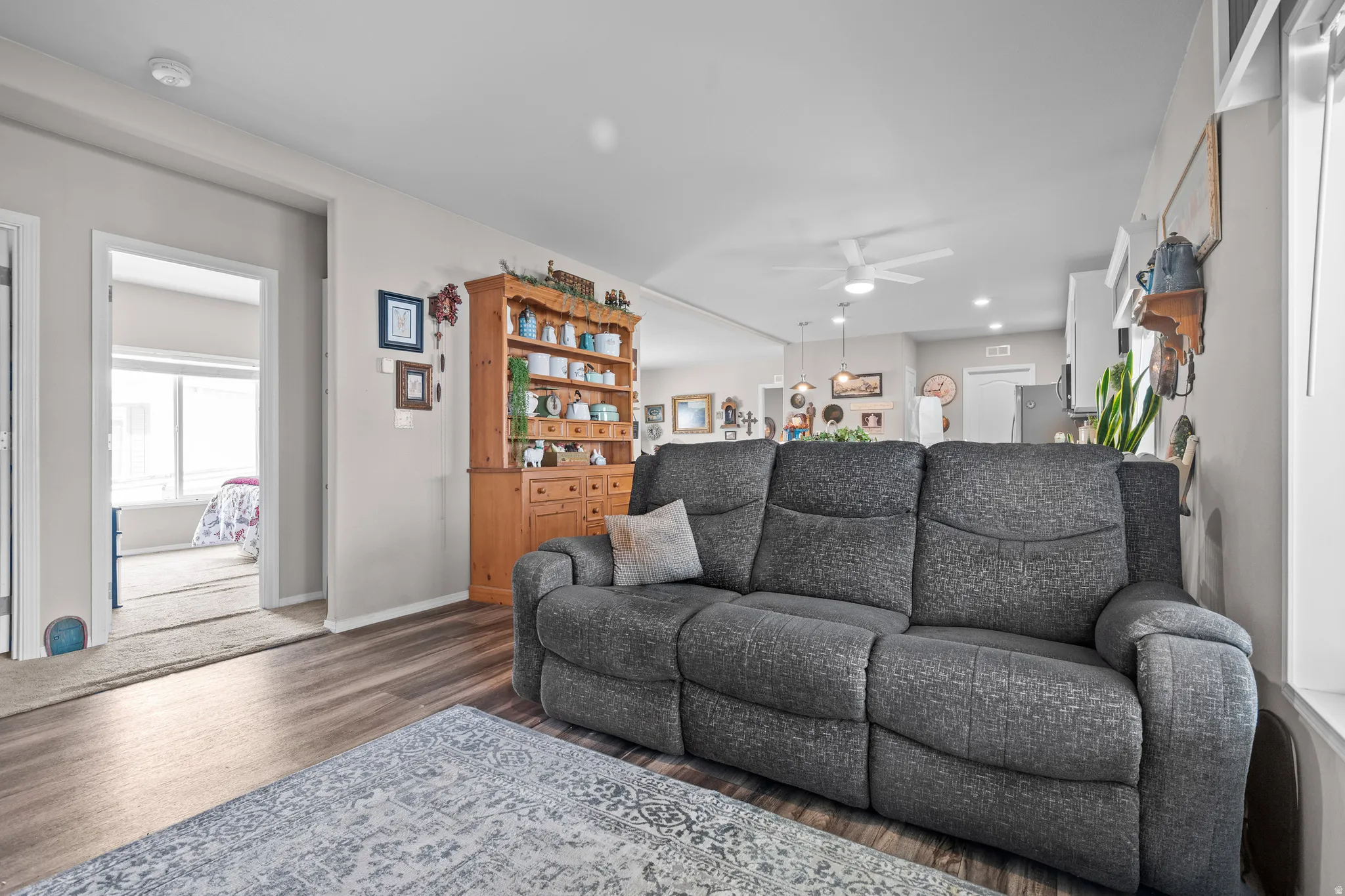 Open concept living area with wood-finish flooring, light neutral wall tones, and recessed lighting