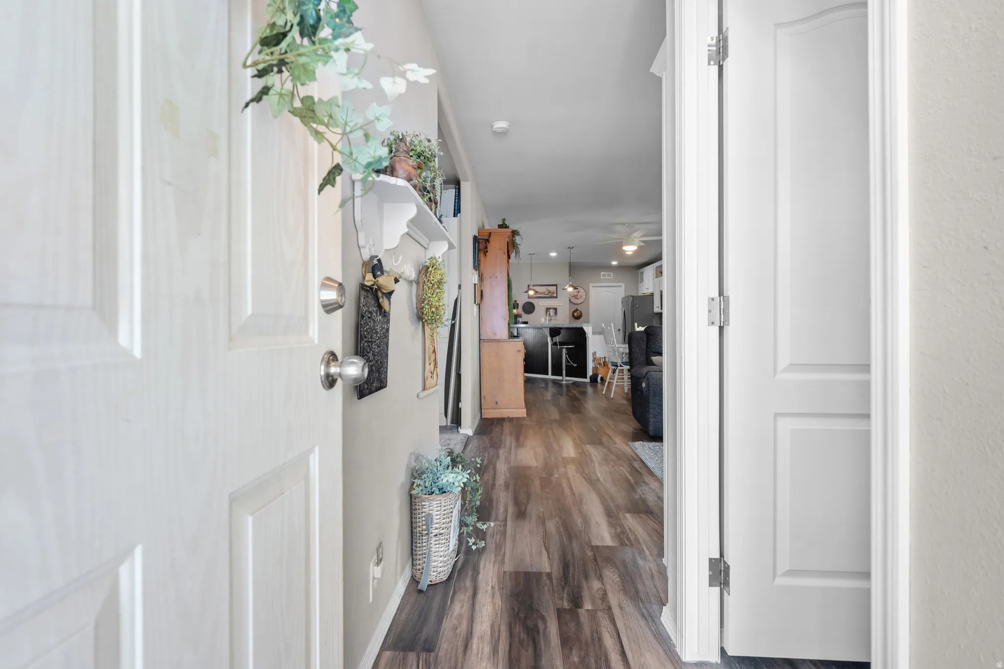 Entryway featuring wood-finish flooring, white paneled doors, and a neutral wall color