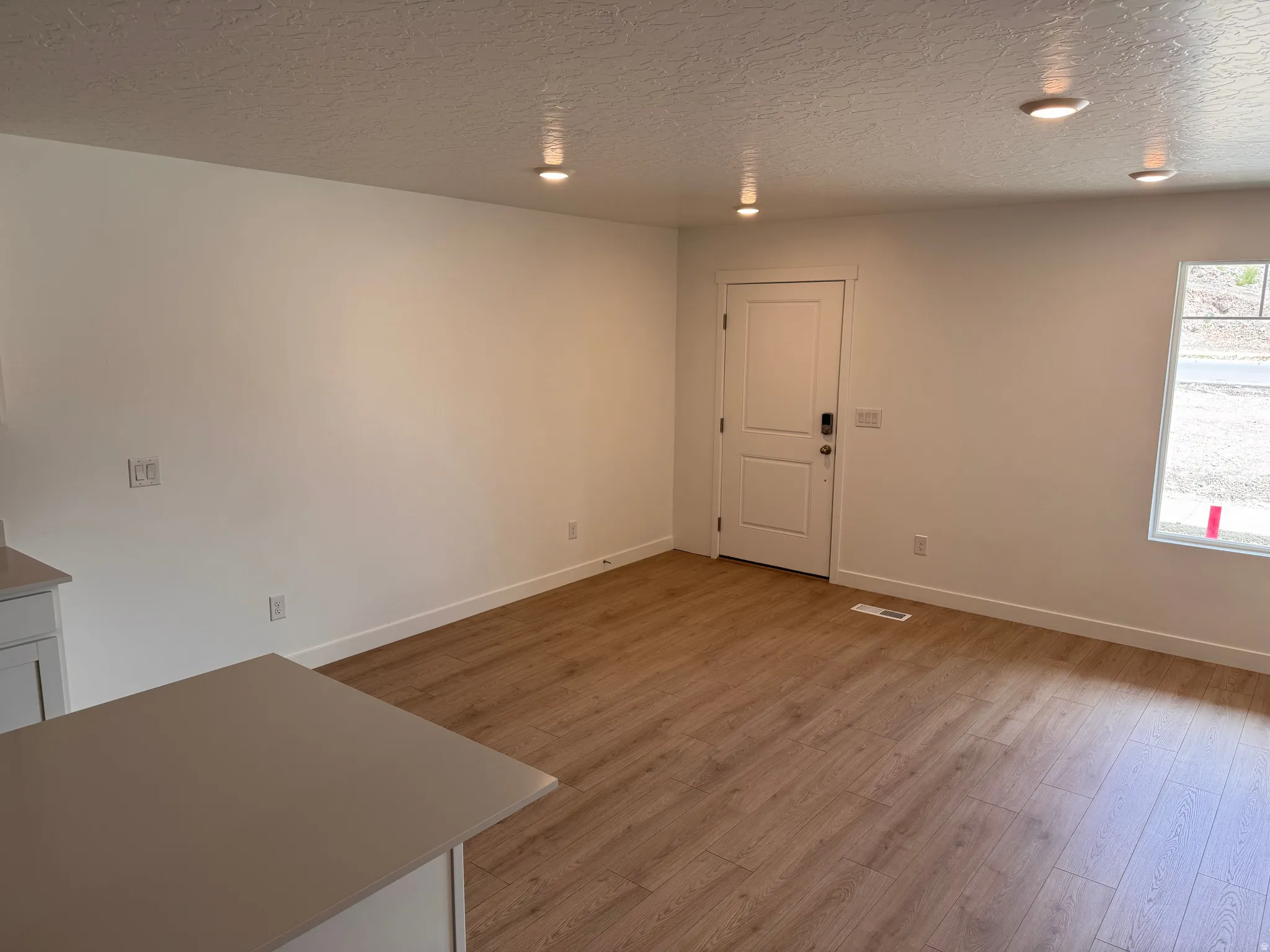 Open concept living area featuring wood-finish flooring, recessed lighting, and a neutral color palette