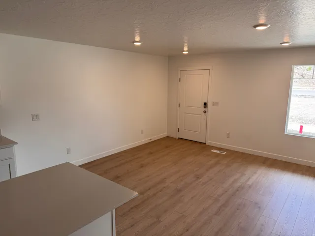 Open concept living area featuring wood-finish flooring, recessed lighting, and a neutral color palette