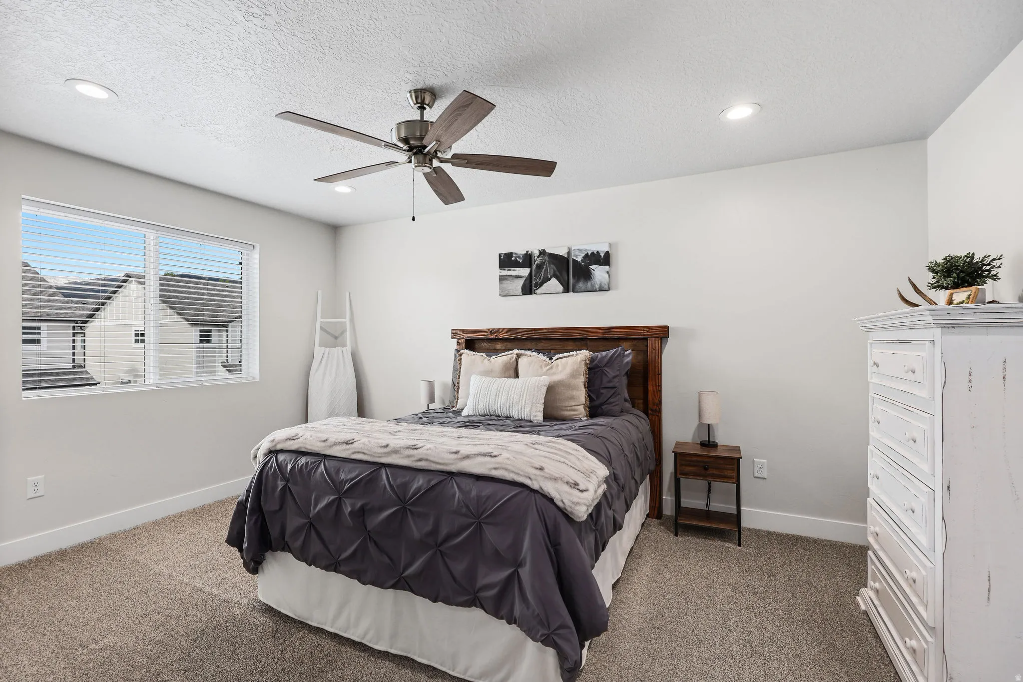 Neutral-toned bedroom featuring a ceiling fan with integrated lighting, recessed ceiling lights, and light-colored carpeting