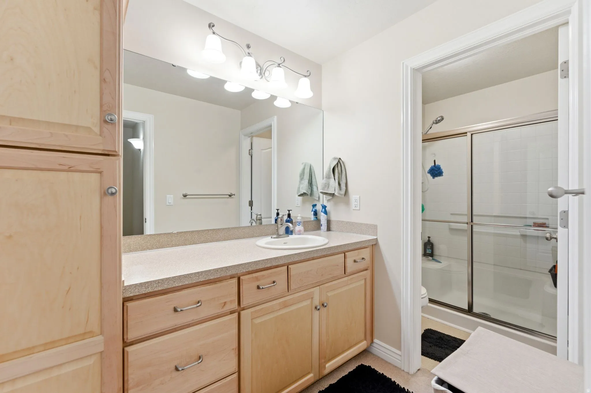 Vanity with light-toned cabinetry, a speckled countertop, and an integrated sink