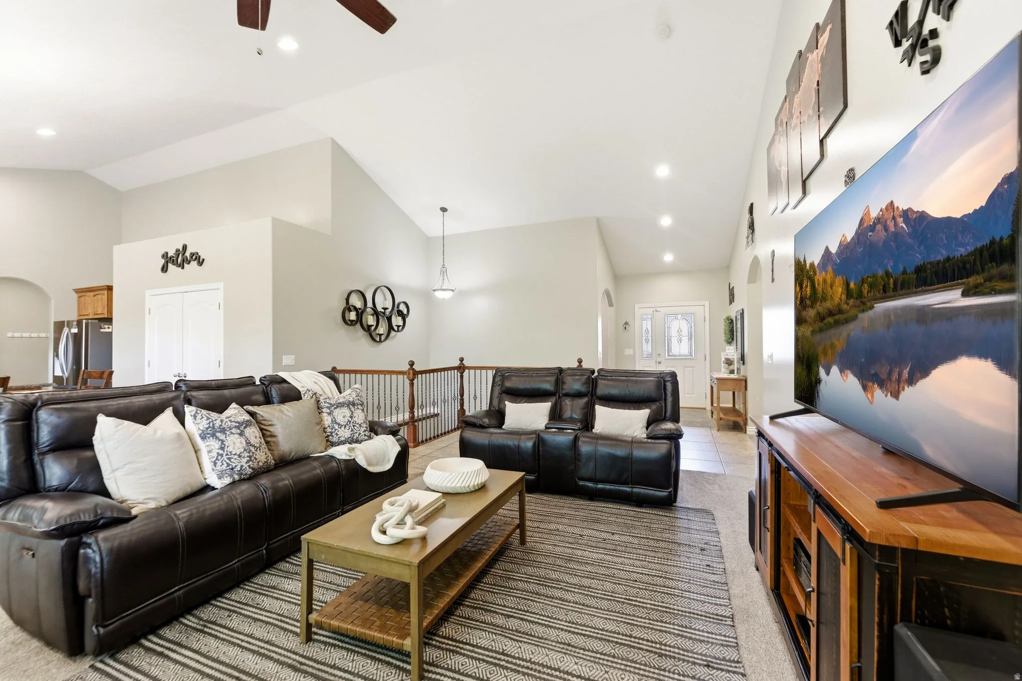 Spacious living area featuring vaulted ceilings, recessed lighting, and a ceiling fan