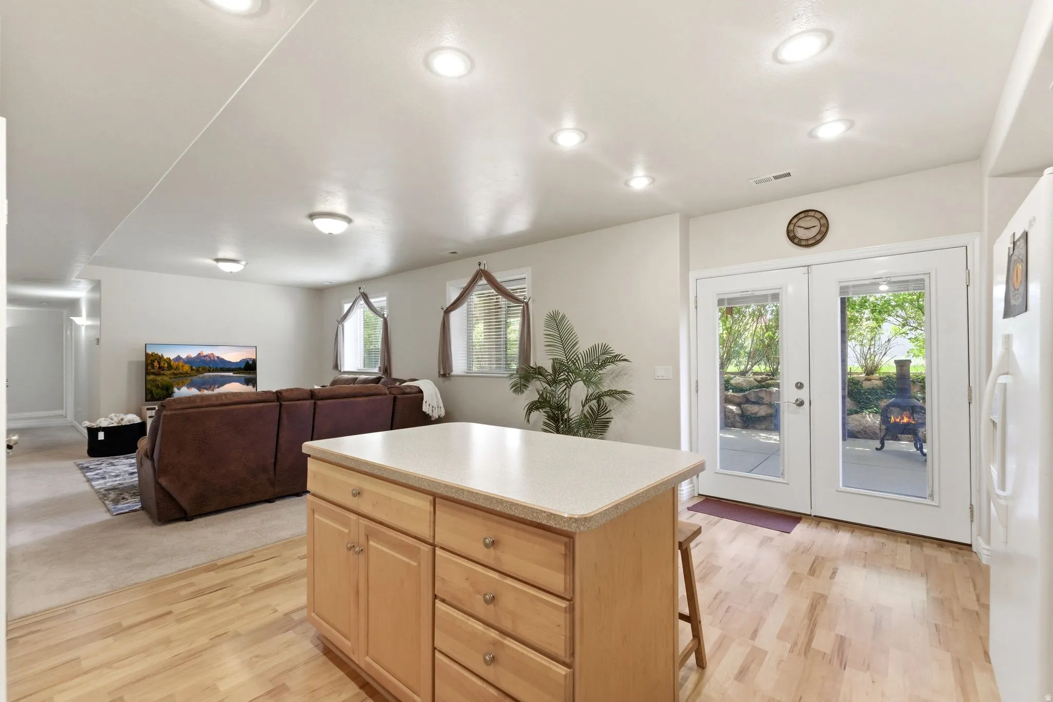 Kitchen island with light wood cabinetry and a light-colored countertop
