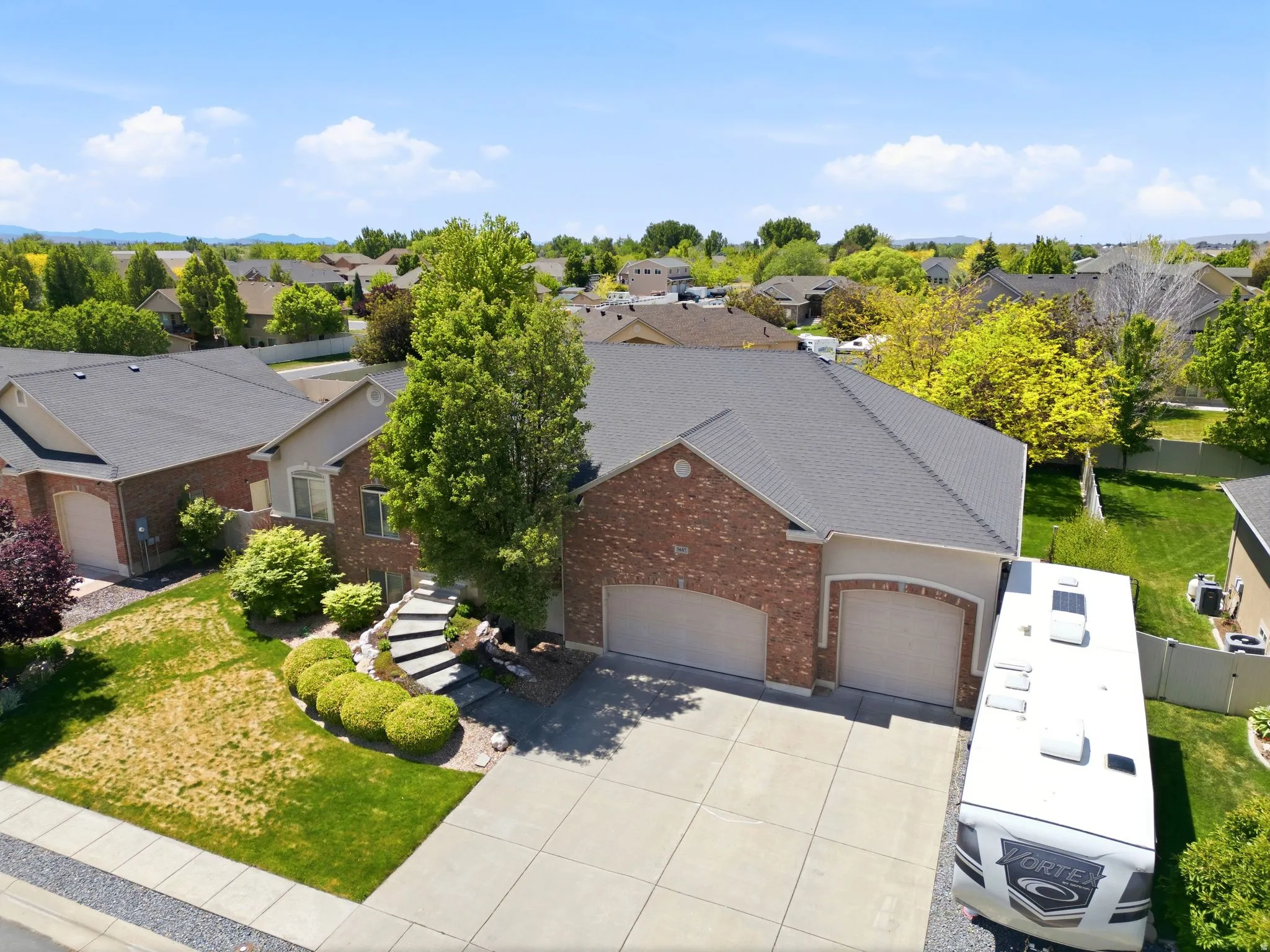 Brick and stucco exterior with a dark shingle roof